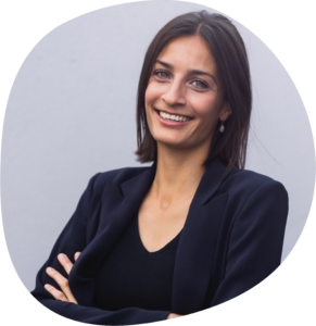 Marie trägt einen schwarzen Blazer und schulterlange braune Haare