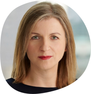 Eva hat lange blonde Haare und trägt roten Lippenstift und ein schwarzes Oberteil