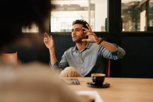 Mann im Gespräch, gestikulierend, gegenüber eine zuhörende Person