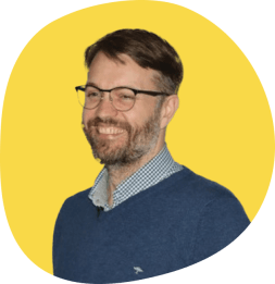 Portrait von Sebastian Tillmann vor gelbem Hintergrund