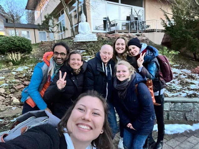 7 Personen aus dem Team der diversity company stehen vor einem buddhistischen Kloster im Odenwald und grinsen in die Kamera